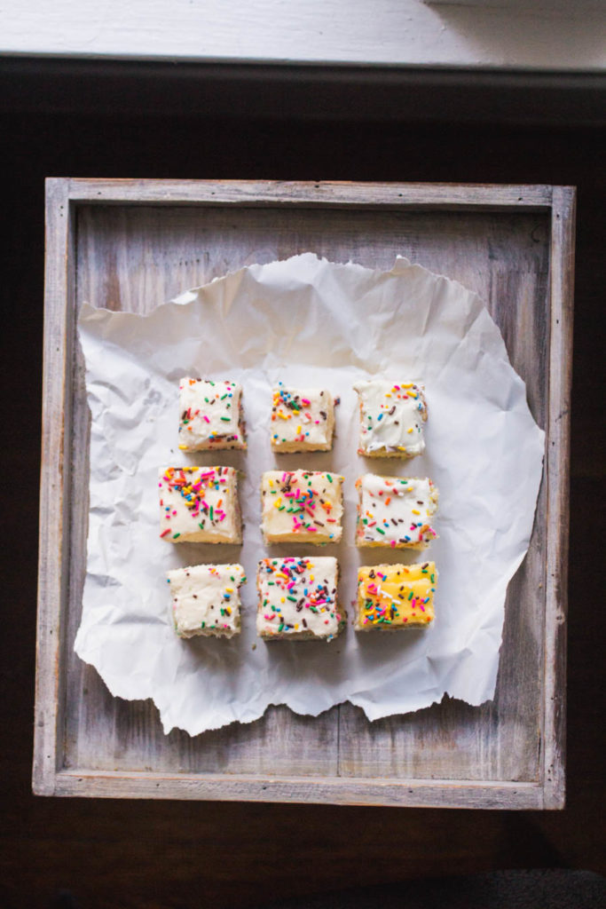 9 slices of different sprinkle cake recipes on white parchment paper