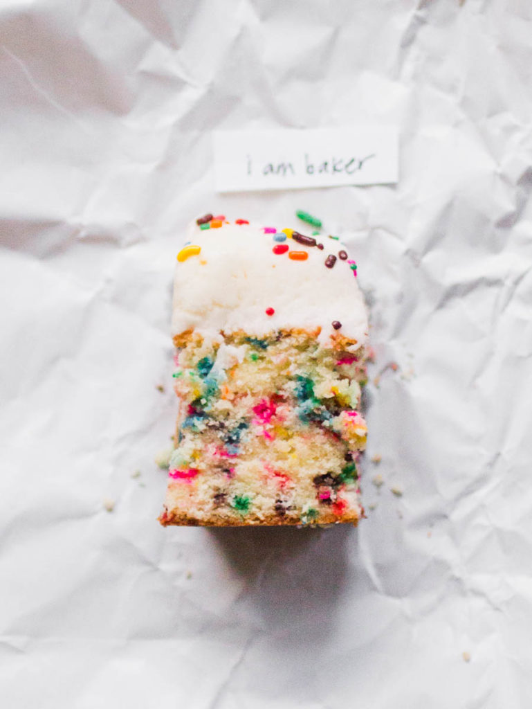 Single slice of I am Baker sprinkle cake recipe one white parchment paper
