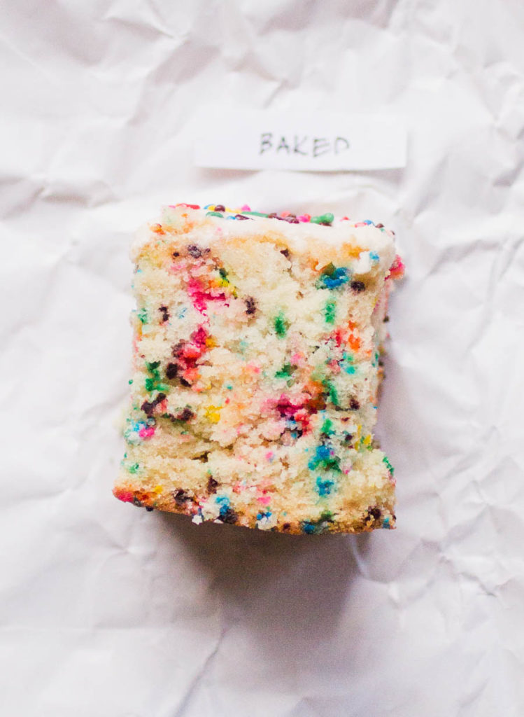 Single slice of Baked sprinkle cake recipe on white parchment paper