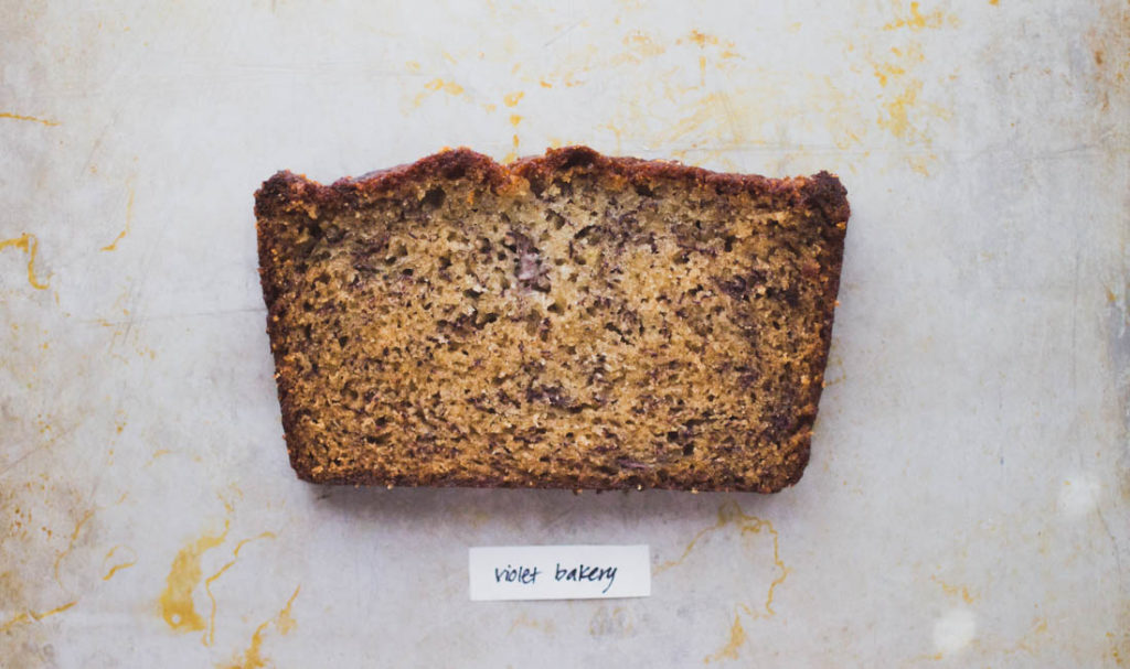 A slice of tall buttermilk-laced banana bread on baking tray - Recipe by Violet Bakery
