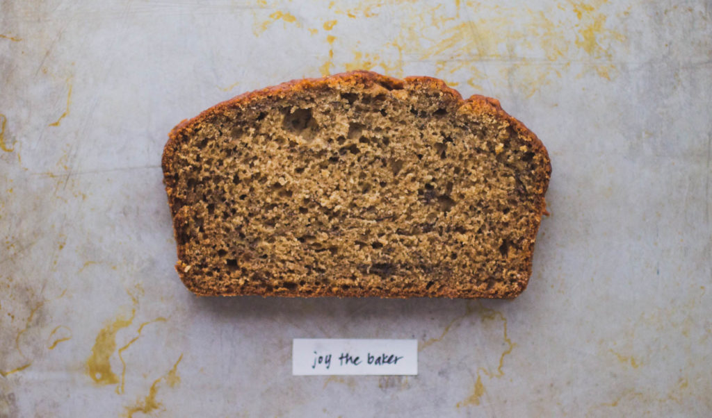 A slice of fluffy crumbed brown butter banana bread on baking tray - Recipe by Joy the Baker