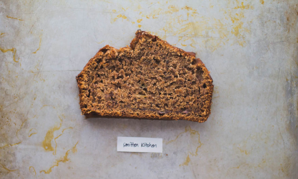 A tall high peaked banana bread slice filled with warming fall-esque spices on baking tray - Recipe by Smitten Kitchen