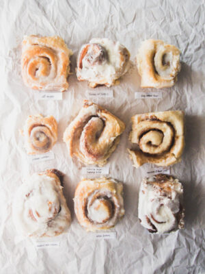 9 different cinnamon rolls on a gray background.