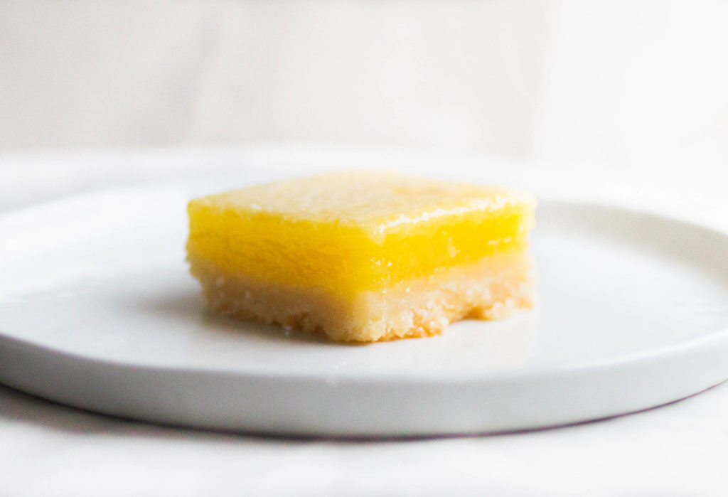single slice of sally's baking addiction lemon bars on white plate