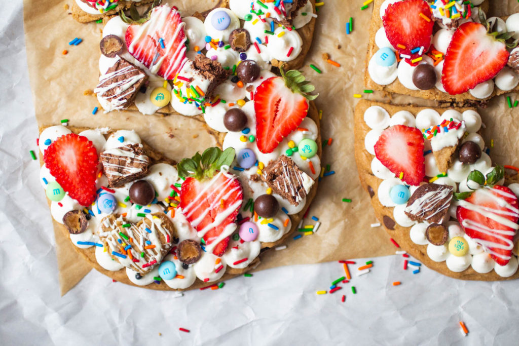 birthday cookie cake shaped like the numbers 35 topped with frosting, fruit and candy