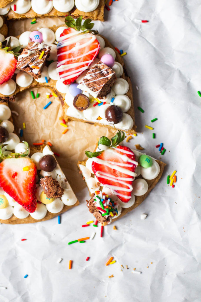 birthday cookie cake shaped like the numbers 35 topped with frosting, fruit and candy