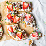 birthday cookie cake shaped like the numbers 35 topped with frosting, fruit and candy