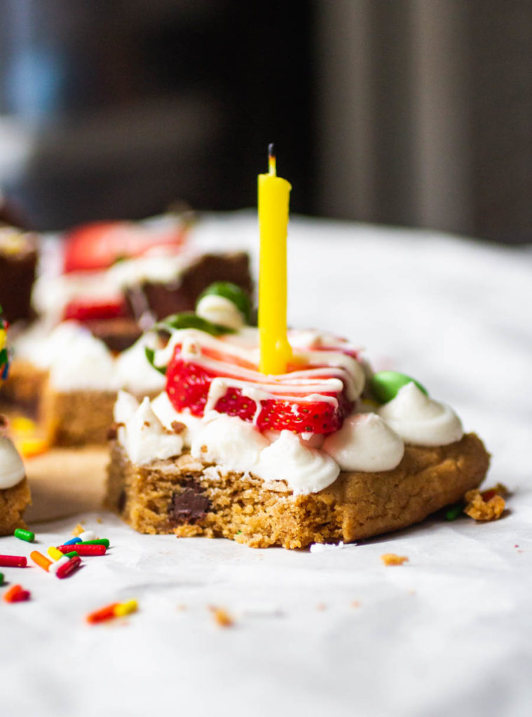 cookie cake with frosting, strawberry and a candle