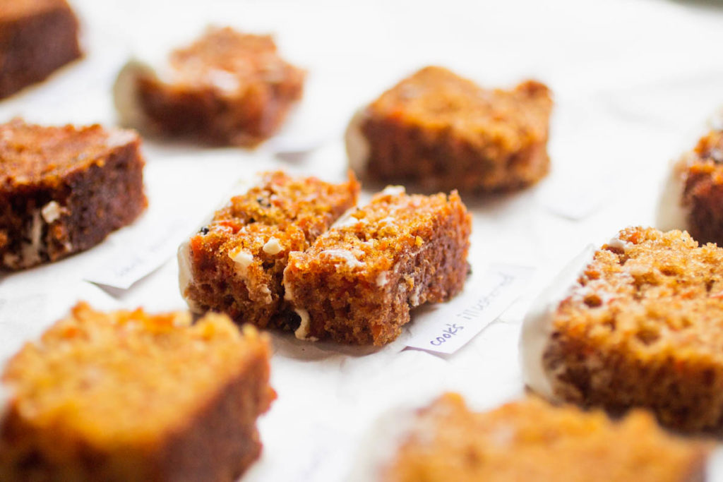 sideways shot of a baking tray with 8 small slices of carrot cake side by side