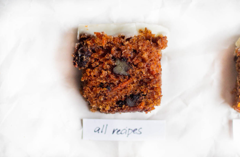 Single slice of all recipes carrot cake recipe on white parchment paper