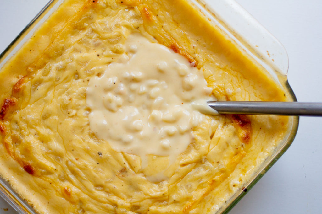 a spoon in a pan of creamy mac and cheese