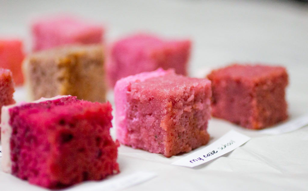 several slices of strawberry cake sideways on white parchment paper