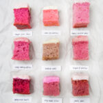 9 squares of different frosted strawberry cake on a crinkled white background