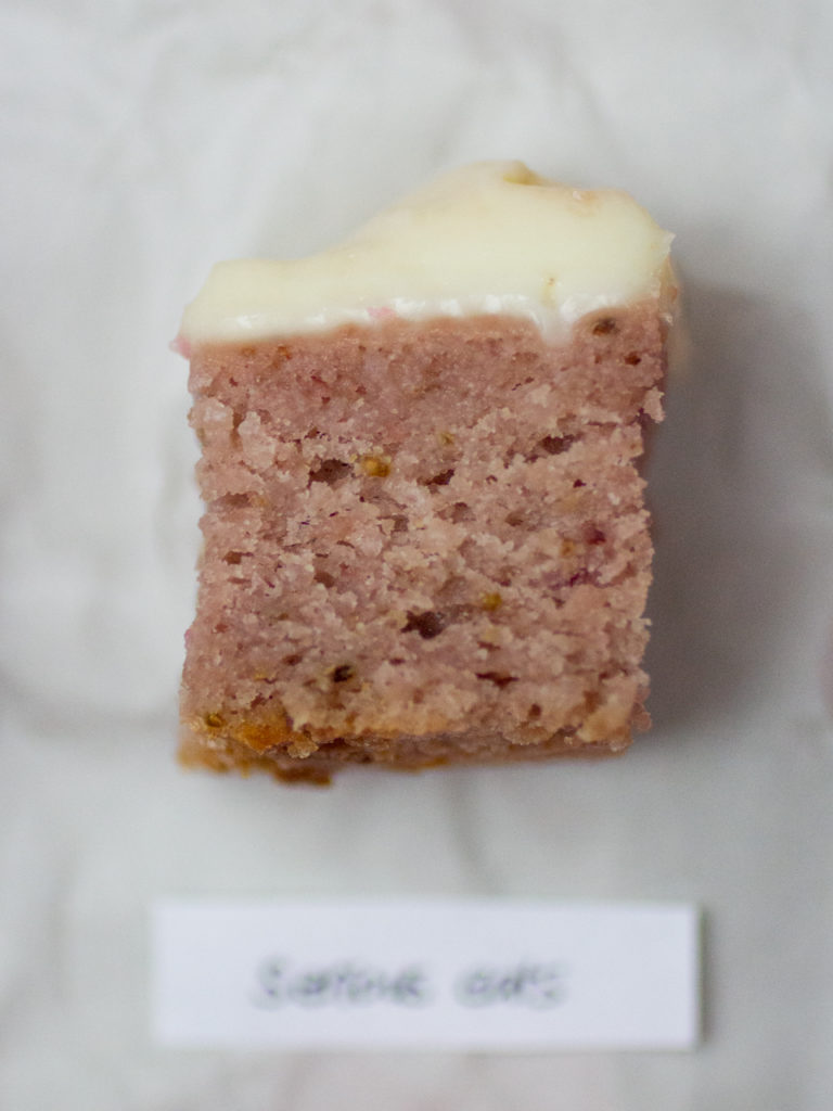 Single slice of strawberry cake by Serious Eats on white parchment paper