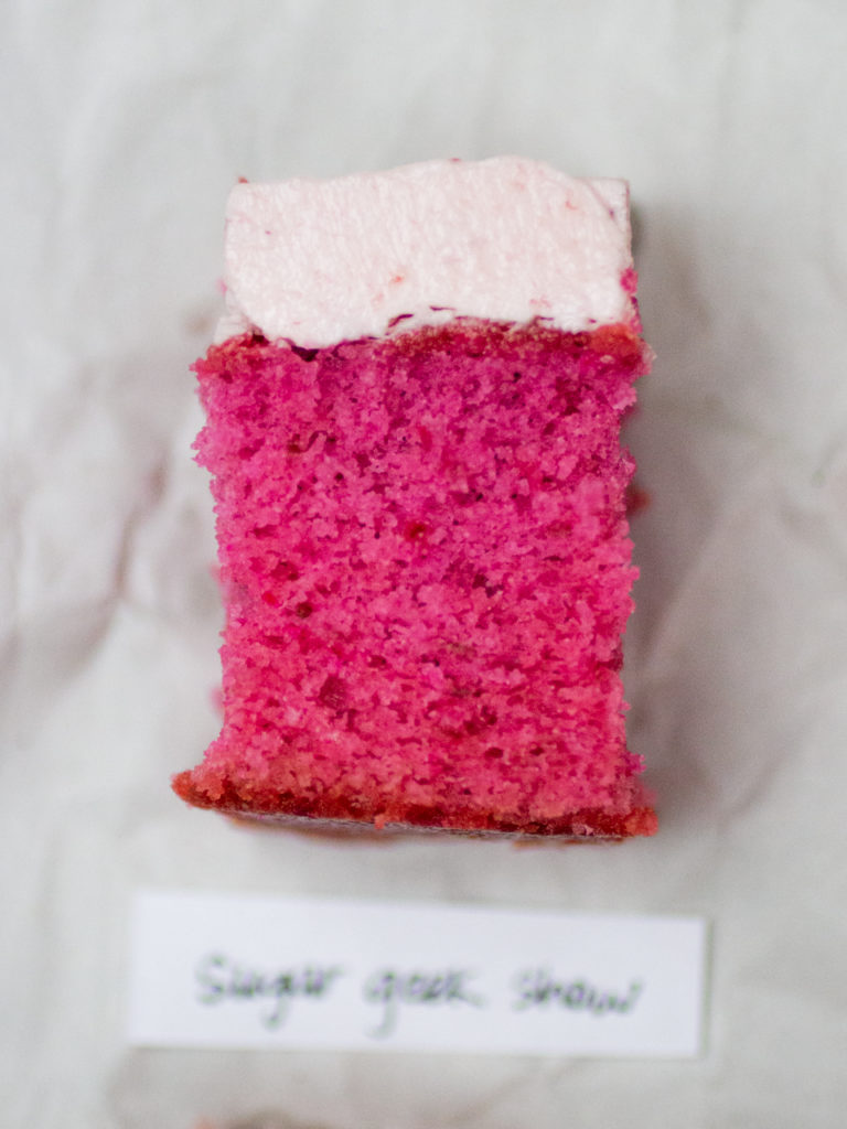 Slice of pink strawberry cake by Sugar Geek Show on white parchment paper