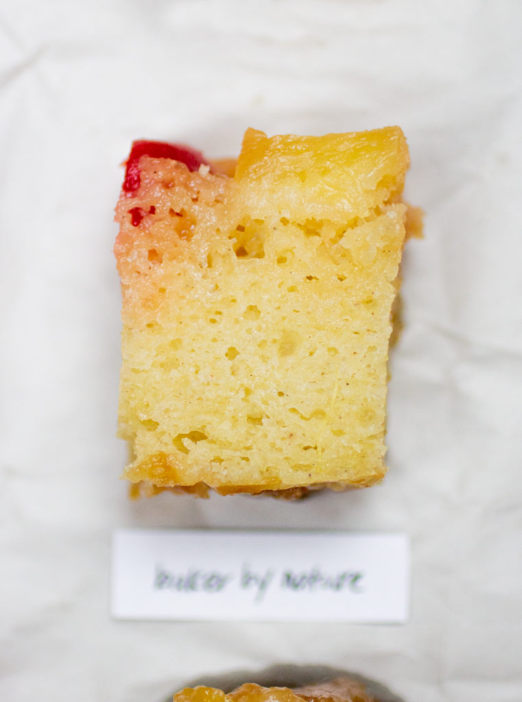 chunk of pineapple upside down cake on a crinkled white paper background