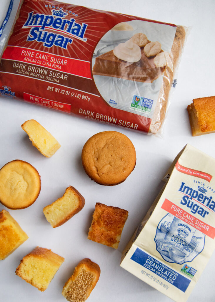 9 butter mochi pieces on gray background with two bags of imperial sugar