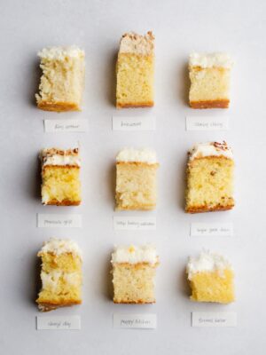 9 pieces of frosted coconut cake laid out in a grid on a light gray background.