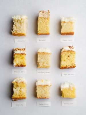 9 pieces of frosted coconut cake laid out in a grid on a light gray background