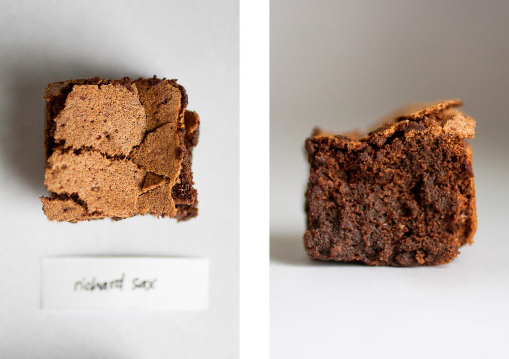 a square of flourless chocolate cake on a gray background