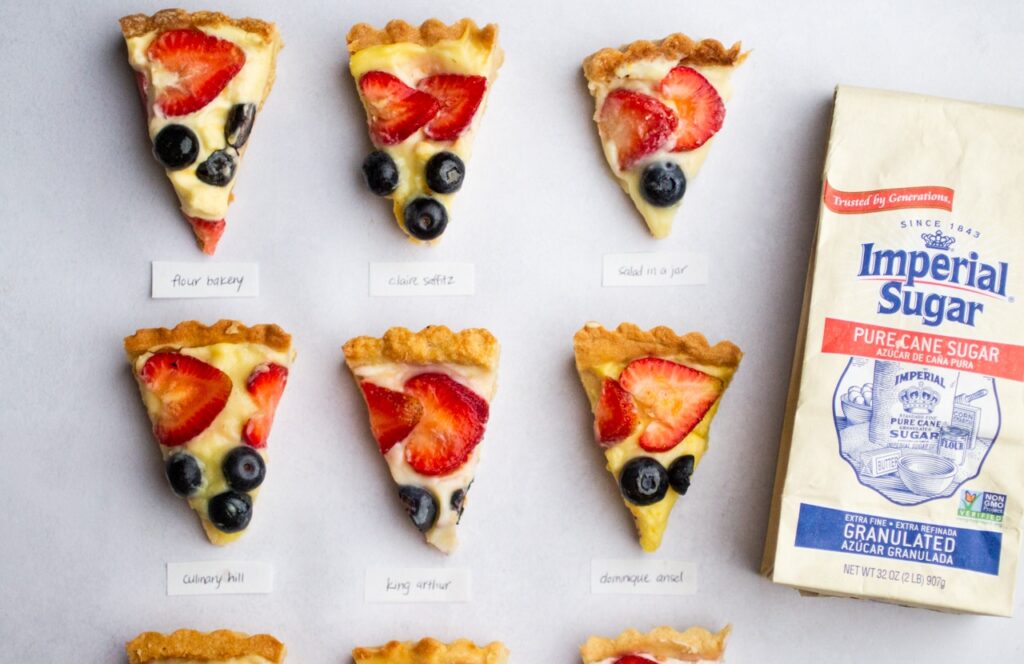 9 slices of fruit tart on a gray background.