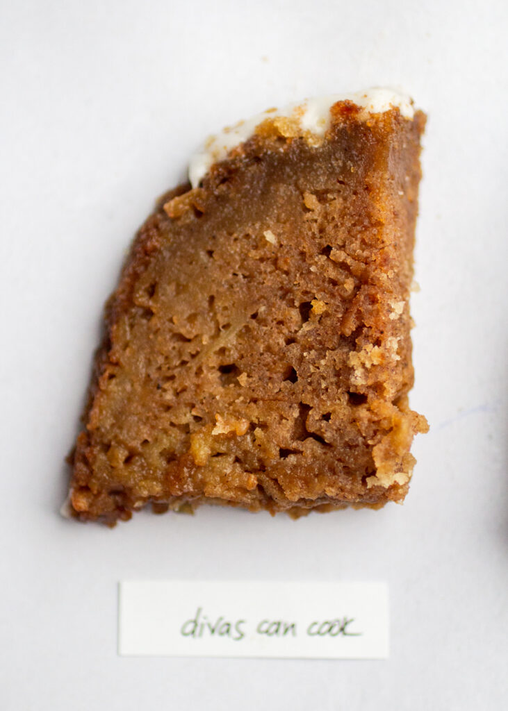 a slice of apple cake with the label \"divas can cook\" on a gray background.