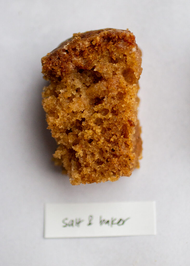 a slice of apple cake with the label \"salt and baker\" on a gray background.