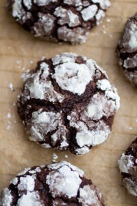 a thick chocolate crinkle cookie on a sheet of parchment paper