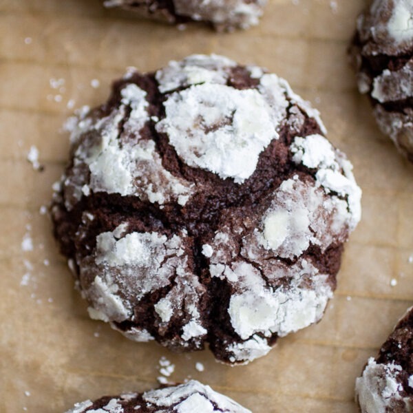 a thick chocolate crinkle cookie on a sheet of parchment paper