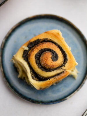 a black sesame sweet roll on a blue plate