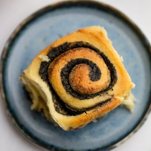 a black sesame sweet roll on a blue plate.