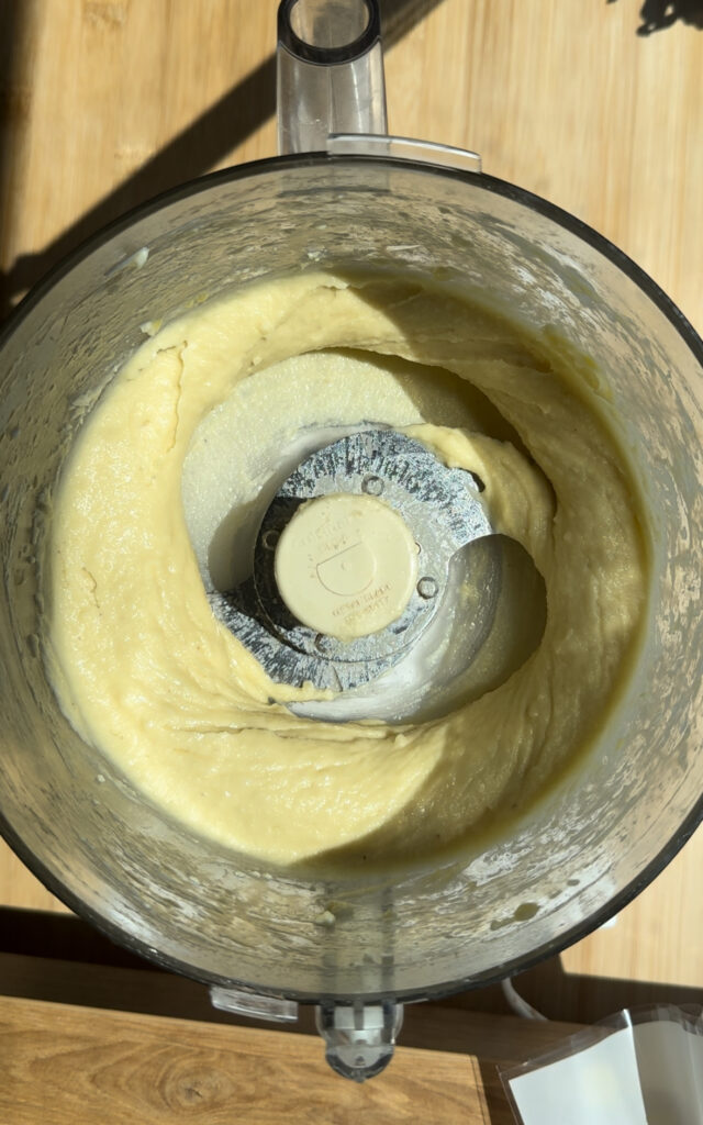 A smooth almond paste in a food processor.