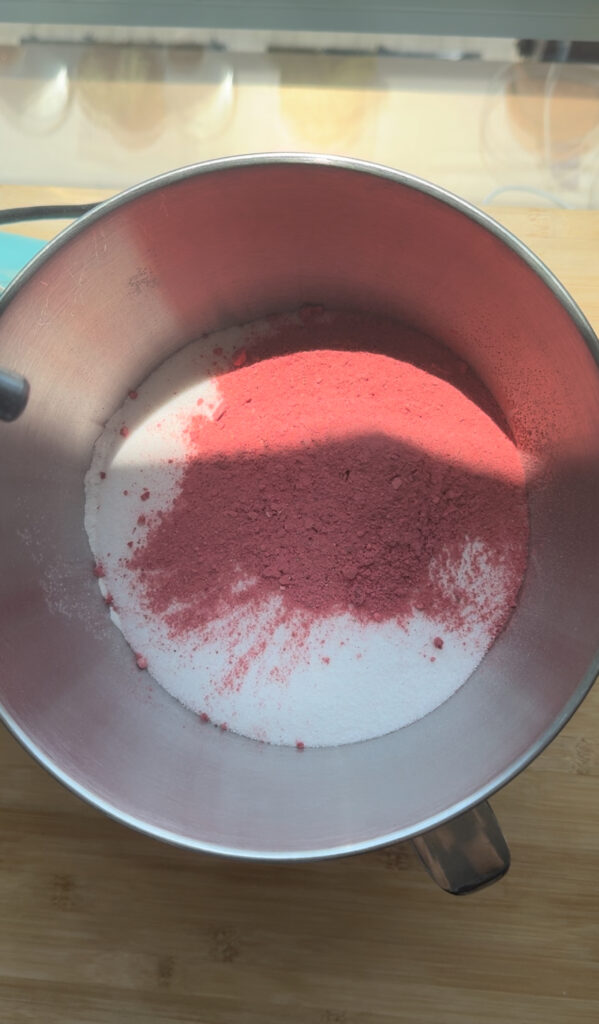 A bowl with freeze-dried strawberries and sugar.