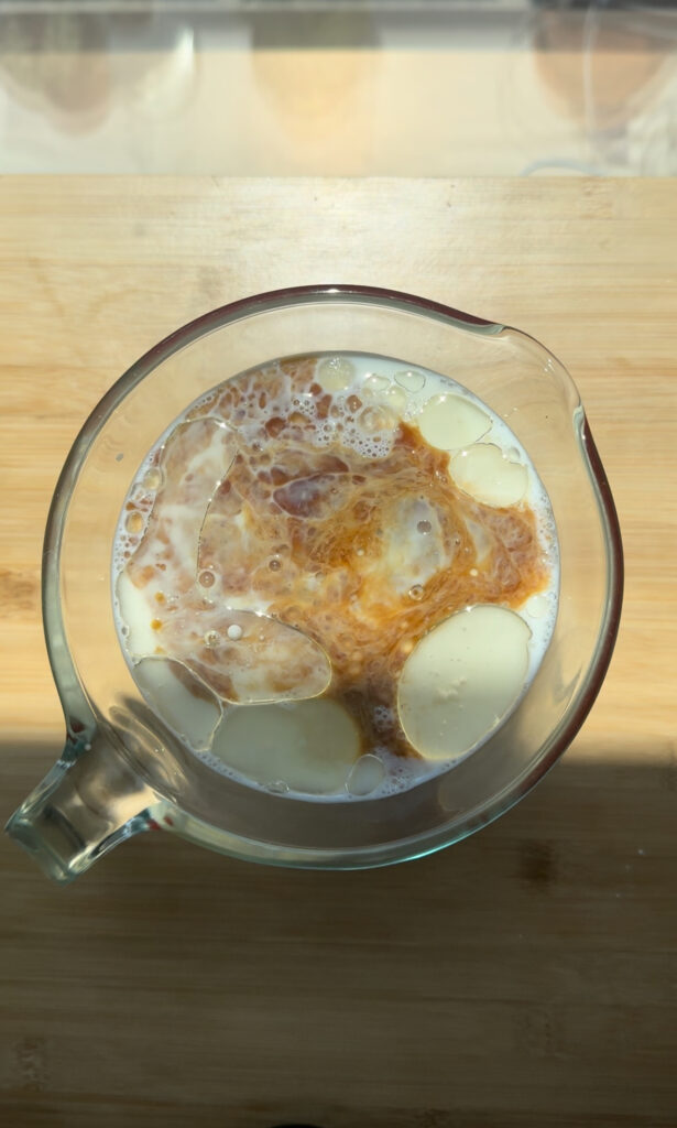 Wet ingredients for strawberry cake in a measuring cup.