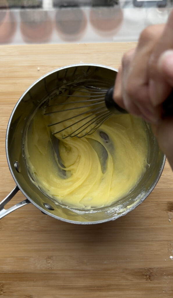 Whisking custard in a saucepan.