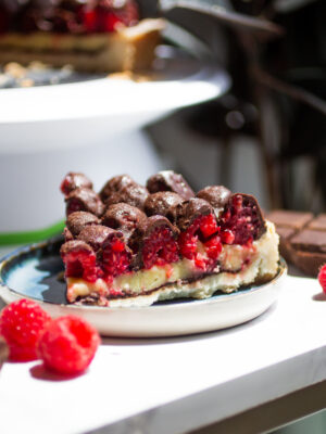 A slice of chocolate raspberry tart on a blue plate.