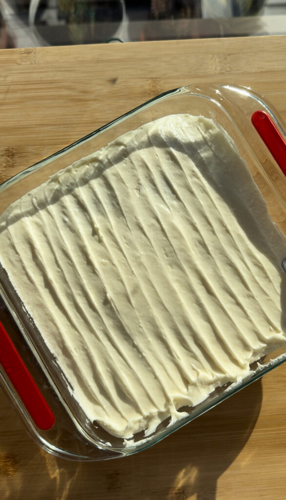 The final frosted pumpkin cake with vertical lines of crema cheese frosting.