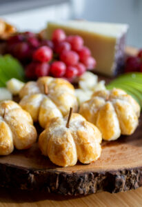 pumpkin-shaped brie bites on a cheeseboard.