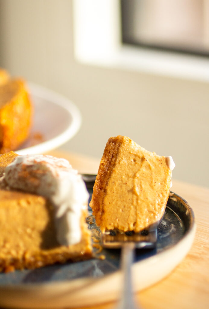 A bite of pumpkin cheesecake on a fork.