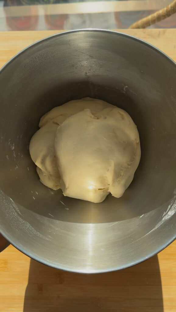 A smooth ball of dough in a mixing bowl.
