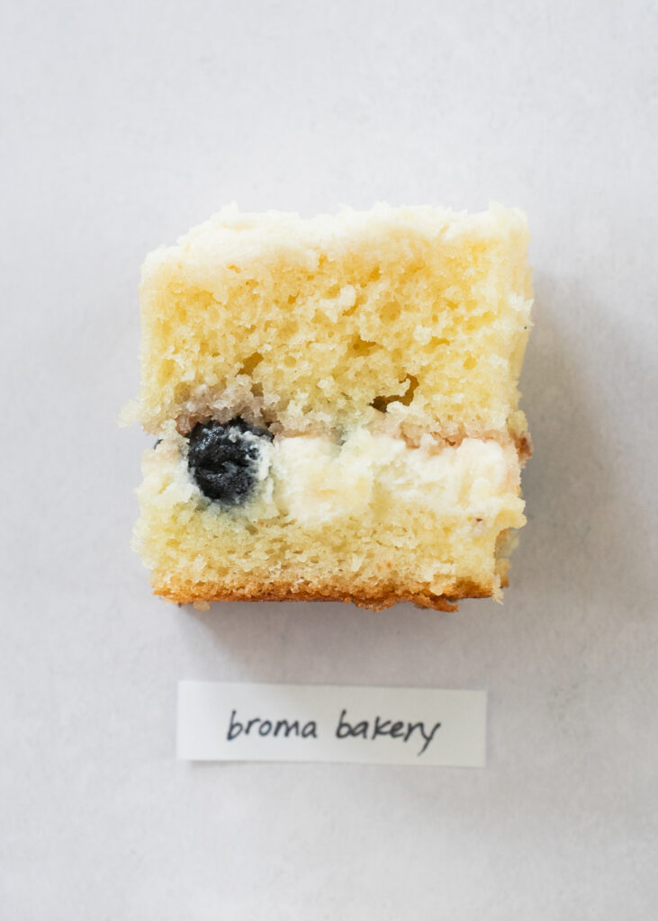 A slice of berry chantilly cake with the label "Broma Bakery."