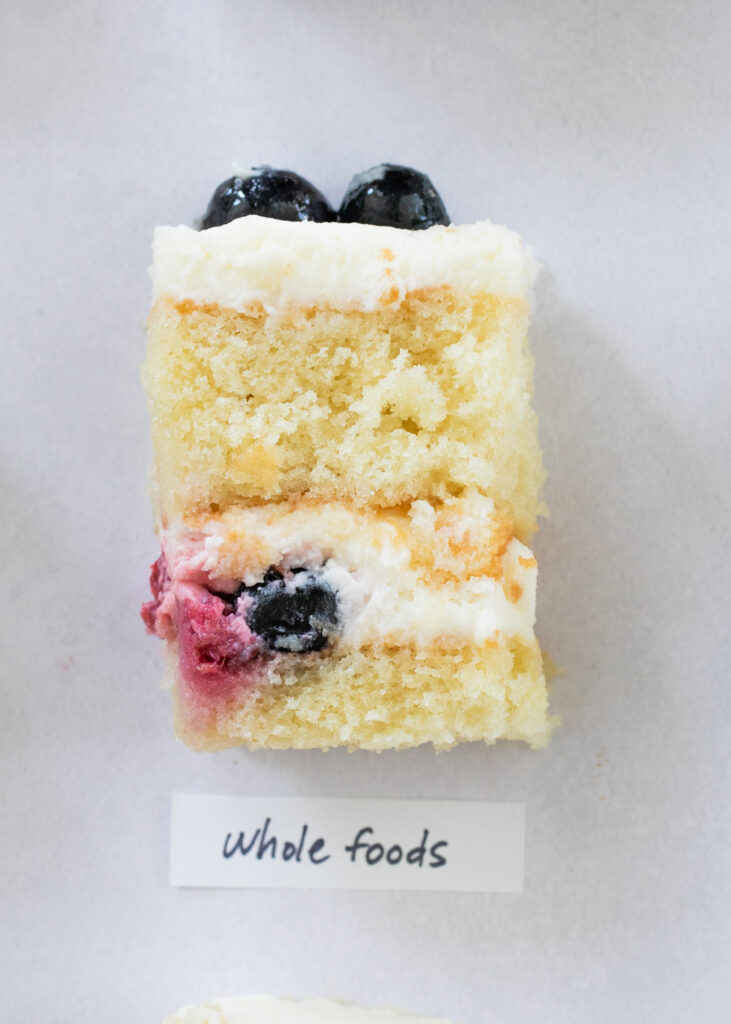 A slice of berry chantilly cake with the label "Whole Foods."