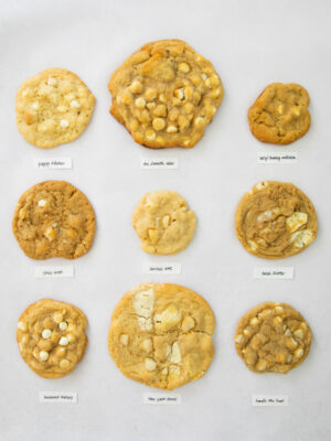 9 different white chocolate macadamia nut cookies on a gray background.