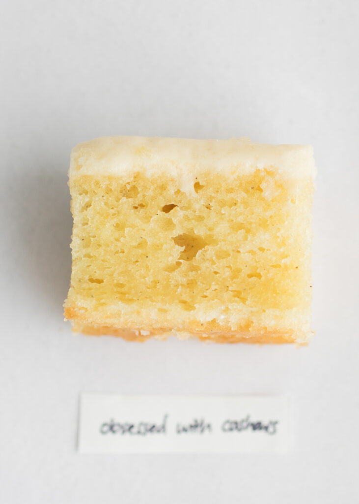 A slice of vegan vanilla cake with a label that says "Obsessed with Cashews."