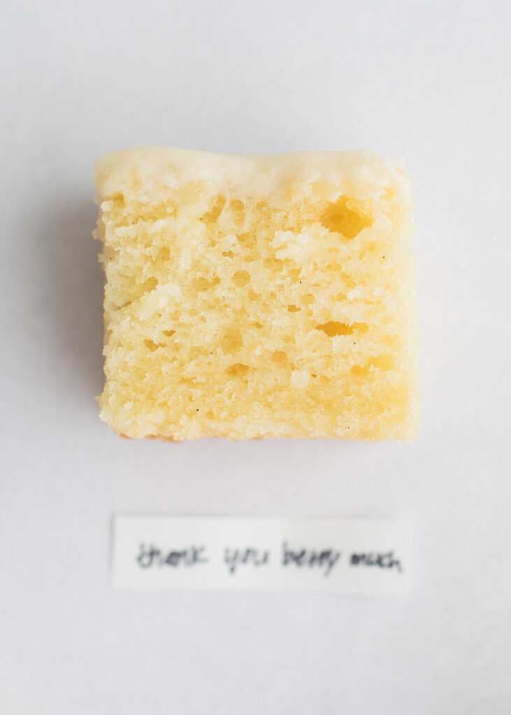 A slice of vegan vanilla cake with a label that says "Thank You Berry Much."