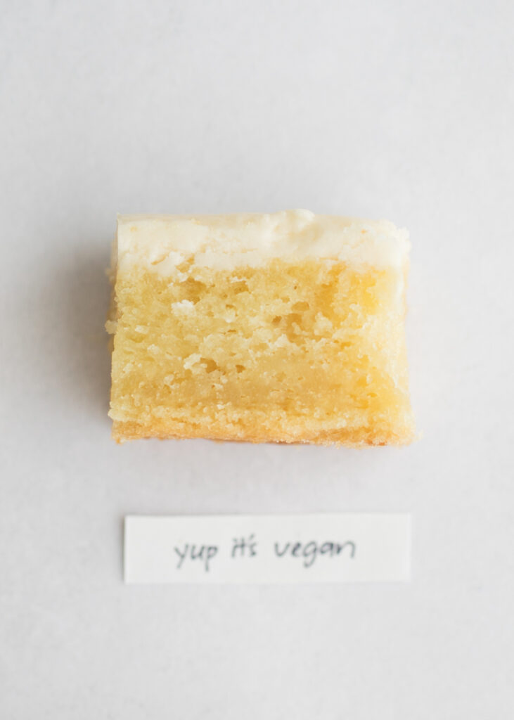 A slice of vegan vanilla cake with a label that says "Yup It's Vegan."