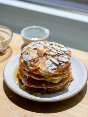 A stack of almond croissants on a white plate.