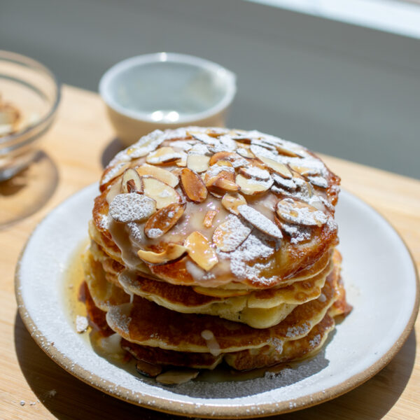 A stack of almond croissants on a white plate.