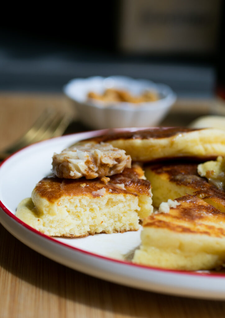 A wedge of pancake pulled away on a plate to show the fluffy interior.